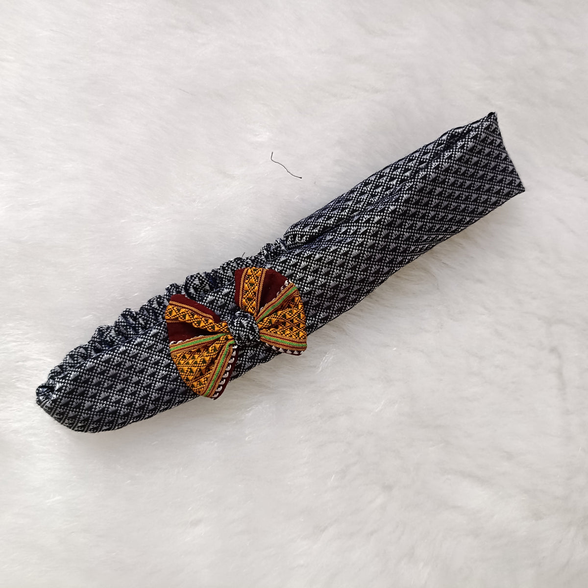 Decorative napkin ring with geometric design on a textured white surface

