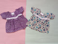 Two baby dresses on a pink and gray background

