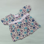 Baby dress with elephant pattern on a light gray background

